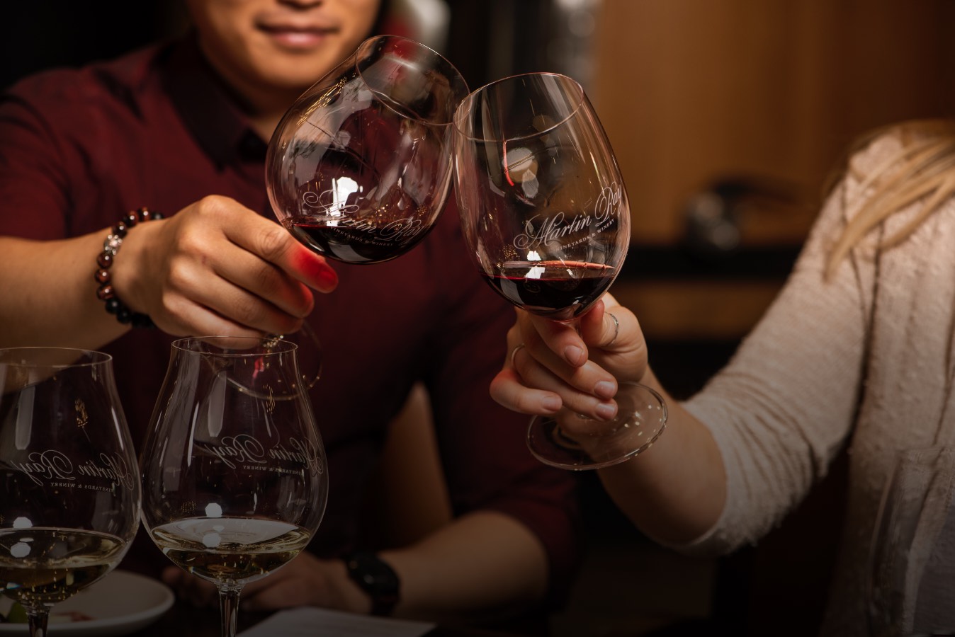 martin-ray-vineyards-and-winery-landing-slider2@2x Two people toasting with Martin Ray wine glasses